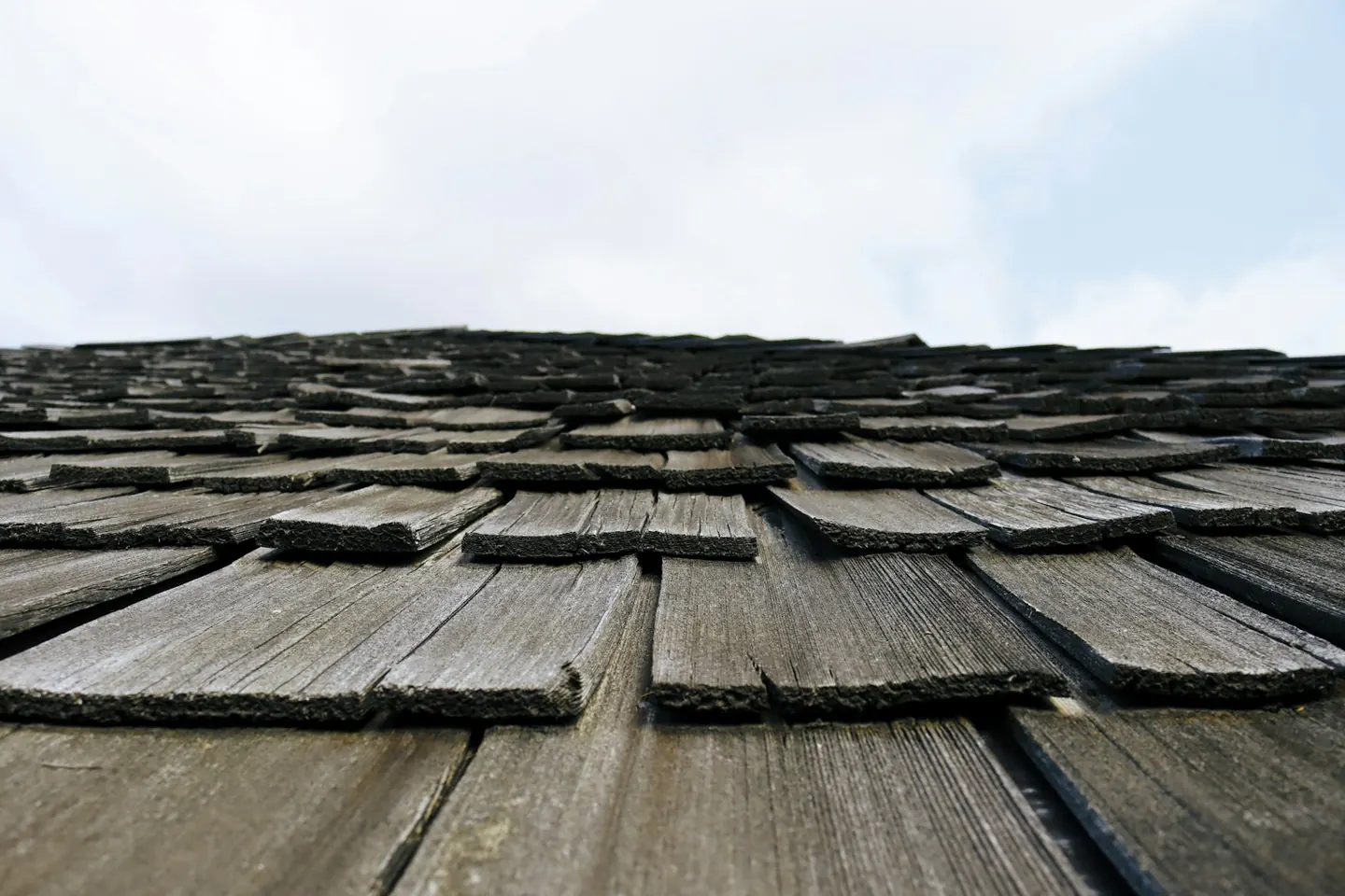 Weathered wood shingles viewed along a roof slope